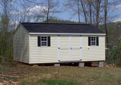 A 12x20 vinyl shed with an a-roof style roof. The shed has a set of double doors and two windows with black shutters. Shed has a 10 foot ridge vent