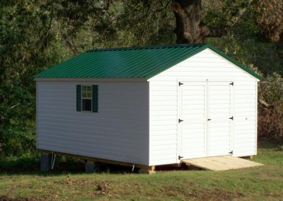 12 x 16 V-A-roof with white siding and trim, green metal roof, and green shutters and treated wooden ramp