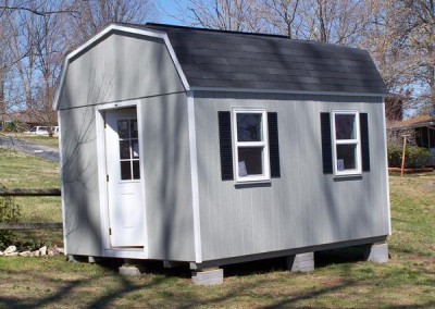 10 x 14 Painted High Barn painted gap gray with white trim, black shingles and shutters, ridgevent, nine light door, house windows and 1' taller walls