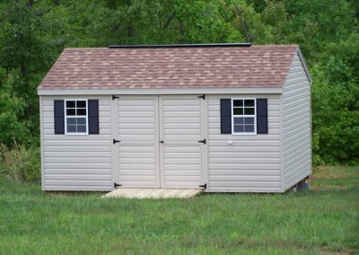 12 x 16 V-A-roof with tan siding and trim, resawn shake shingles, redwood shutters and a ridgevent