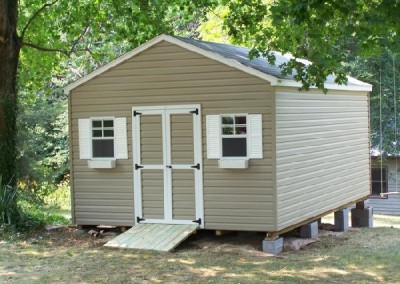 A vinyl 12x20 shed with a 4 foot wide double door. Shed has tow windows on either side of door and a treated wooden ramp