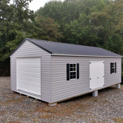 14 x 28 size vinyl a-roof garage style shed with flint siding, white trim, black metal roof, black shutters, 9x7 garage door, 6 foot fiber doors with two windows.