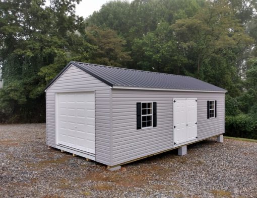 14 x 28 size vinyl a-roof garage style shed with flint siding, white trim, black metal roof, black shutters, 9x7 garage door, 6 foot fiber doors with two windows.