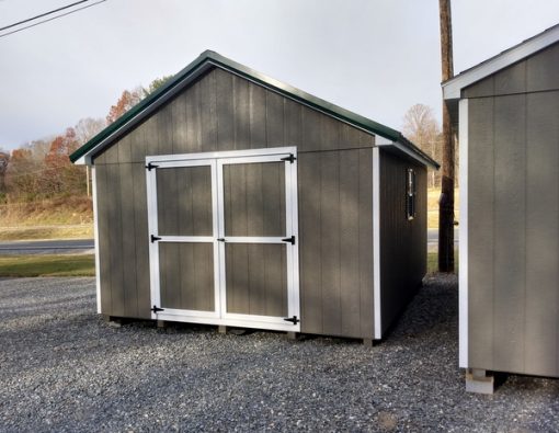 12 x 16 size painted classic style shed with clay siding, white trim, forest green metal roof, green shutters, ggs 6 foot doors, two windows.