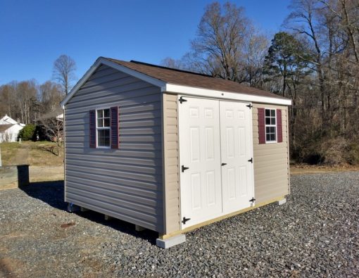 10x12 size vinyl a-roof roof style shed with clay siding, white trim, brownwood architectural shingle roof, burgundy shutters. Has 6 foot fiber doors and two windows.