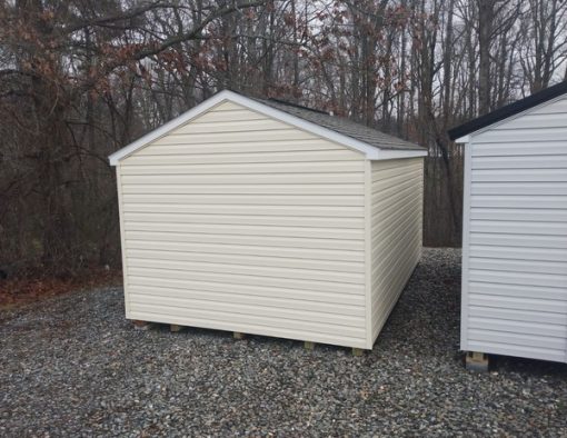 10x16 size vinyl a-roof roof style shed with cream siding, white trim, driftwood architectural shingle roof, slate blue shutters. Has 6 foot fiber doors and two windows.