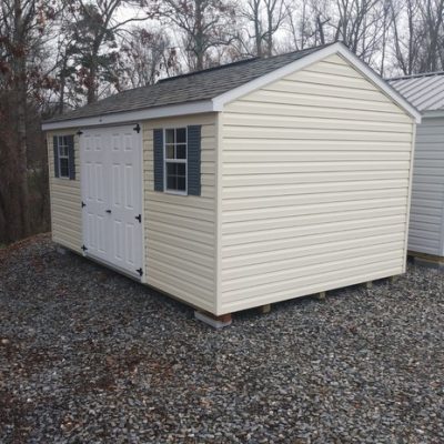 10x16 size vinyl a-roof roof style shed with cream siding, white trim, driftwood architectural shingle roof, slate blue shutters. Has 6 foot fiber doors and two windows.