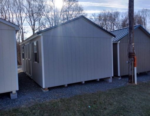 12 x 20 size painted a-roof style shed with gap gray siding, white trim, black metal roof, black shutters, ggs 6 foot doors, two windows.