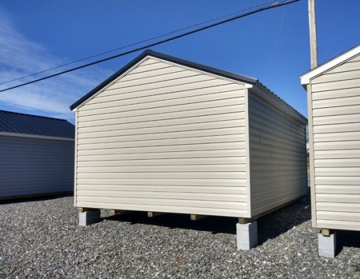 12x16 size vinyl a-roof roof style shed with olive siding, white trim, black metal roof, black shutters. Has 8' ridge vent, 6 foot fiber doors and two windows.