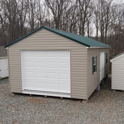 14 x 28 size vinyl a-roof garage style shed with clay siding, white trim, forest metal roof, green shutters, 9x7 garage door, 6 foot fiber 2 plank doors with two windows.