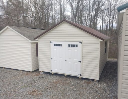 12x20 size vinyl classic roof style shed with almond siding, almond trim, brown metal roof, brown shutters. Has 6 foot fiber transom doors and two windows.