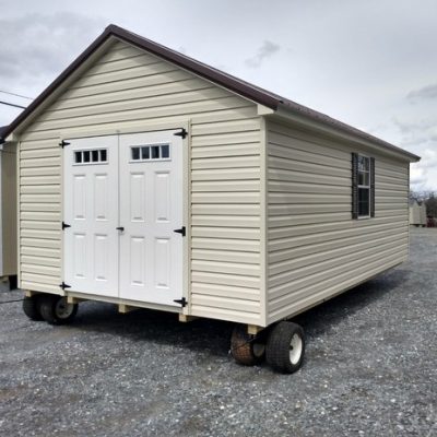 12x20 size vinyl classic roof style shed with almond siding, almond trim, brown metal roof, brown shutters. Has 6 foot fiber transom doors and two windows.