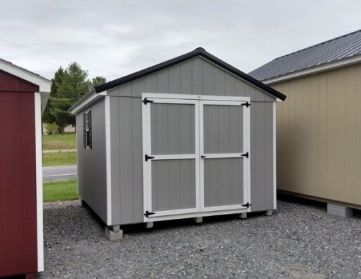 10 x 12 size painted a-roof style shed with gap gray siding, white trim, black metal roof, black shutters, ggs 6 foot doors, two windows.