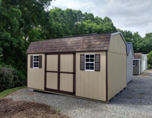 12 x 16 size painted high barn style shed with tan siding, brown trim, brownwood architectural shingle roof, brown shutters, 8' ridge vent, ggs 6 foot doors, two windows.