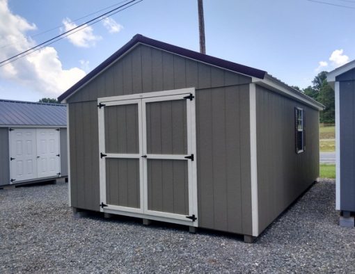 12 x 20 size painted a-roof style shed with clay siding, almond trim, burgundy metal roof, burgundy shutters, ggs 6 foot doors and two windows.
