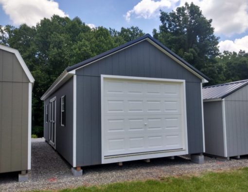 14 x 28 size painted classic garage style shed with gray siding, white trim, black metal roof, black shutters, garage door, ggs 6 foot double doors, two windows.