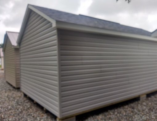 12x20 size vinyl classic roof style shed with flint siding, white trim, black architectural shingle roof, black shutters. Has ridgevent, 6 foot fiber doors and two windows.