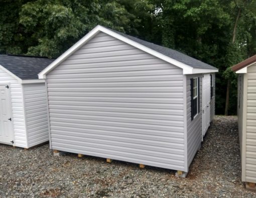 12x20 size vinyl classic roof style shed with flint siding, white trim, black architectural shingle roof, black shutters. Has ridgevent, 6 foot fiber doors and two windows.