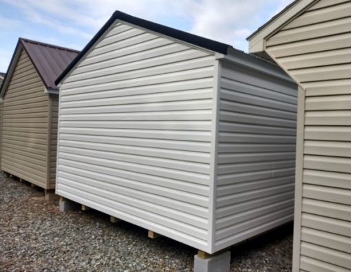 12x20 size vinyl a-roof roof style shed with white siding, white trim, black metal roof, black shutters. Has 6 foot fiber doors and two windows.