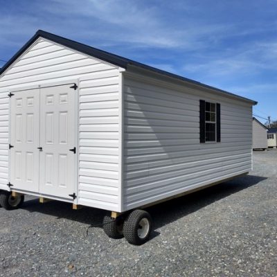 12x20 size vinyl a-roof roof style shed with white siding, white trim, black metal roof, black shutters. Has 6 foot fiber doors and two windows.