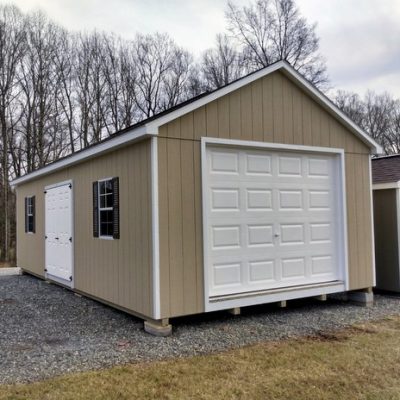 14 x 28 size painted classic garage style shed with tan siding, white trim, brownwood architectural shingle roof, brown shutters, 16' ridge vent, garage door, fiber 6 foot double doors, two windows.