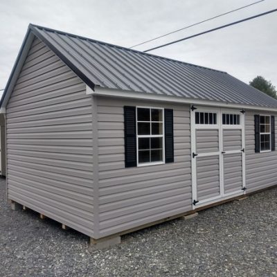 12 x 20 size vinyl garden style shed with flint siding, white trim, black metal roof, black shutters, ggs transom 6 foot doors, two windows.