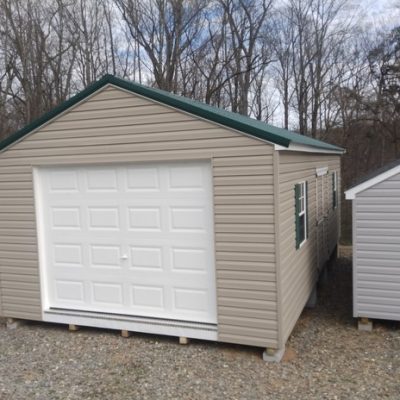 14 x 28 size vinyl a-roof garage style shed with clay siding, white trim, forest metal roof, green shutters, 9x7 garage door, 6 foot ggs doors with two windows.
