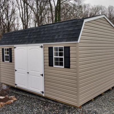 12x16 size vinyl high barn roof style shed with clay siding, white trim, black architectural shingle roof, black shutters. has 8' ridge vent, 6 foot fiber 2 plank doors and two windows.