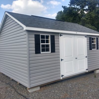 12x16 size vinyl classic roof style shed with flint siding, white trim, estate gray architectural shingle roof, black shutters. Has 8' ridge vent, 6 foot fiber 2 plank doors and two windows.