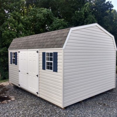 12x16 size vinyl high barn roof style shed with mist siding, white trim, driftwood architectural shingle roof, navy blue shutters. has 8' ridge vent, 6 foot fiber doors and two windows.