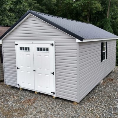 12 x 20 size vinyl classic style shed with flint siding, white trim, black metal roof, black shutters, fiber transom 6 foot doors, two windows.