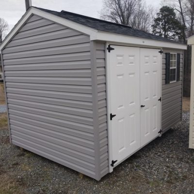 8x12 size vinyl a-roof style shed with flint siding, white trim, black architectural shingle roof, black shutters. Has 8' ridge vent, 6 foot fiber doors and one window.