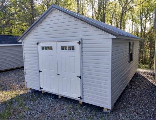 12 x 20 size vinyl classic style shed with gray siding, gray trim, charcoal metal roof, black shutters, fiber 6 foot transom doors, two windows.