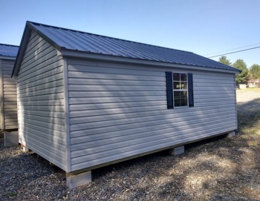 12 x 20 size vinyl classic style shed with gray siding, gray trim, charcoal metal roof, black shutters, fiber 6 foot transom doors, two windows.