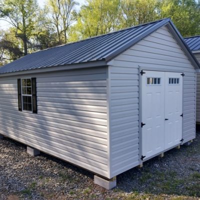 12 x 20 size vinyl classic style shed with gray siding, gray trim, charcoal metal roof, black shutters, fiber 6 foot transom doors, two windows.