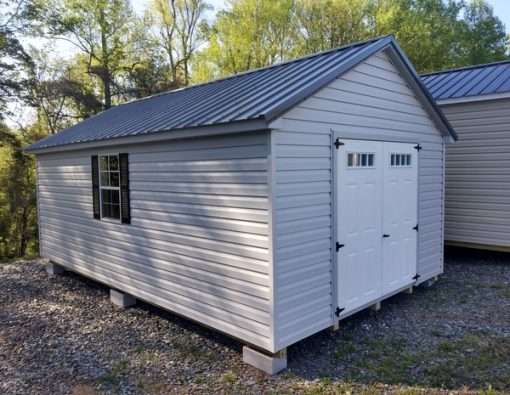 12 x 20 size vinyl classic style shed with gray siding, gray trim, charcoal metal roof, black shutters, fiber 6 foot transom doors, two windows.