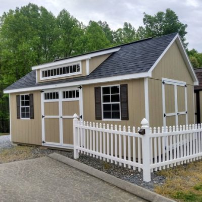 12 x 20 size painted garden style shed with tan siding, white trim, black architectural shingle roof, brown shutters, shed dormer, transom window, (2) 8' ridge vents, ggs transom 6 foot doors, ggs 6 foot doors, two windows.