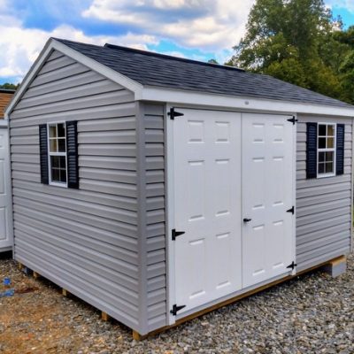 10x12 size vinyl a-roof style shed with flint siding, white trim, black architectural shingle roof, black shutters. has (1) 8' ridge vent, 6 foot fiber doors and two windows.
