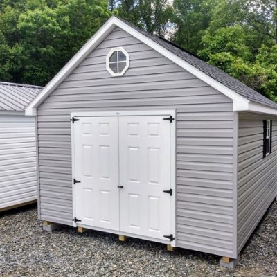 12x16 size vinyl garden roof style shed with flint siding, white trim, black architectural shingle roof, black shutters. has (1) 8' ridge vent, (1) octagon window, 6 foot fiber doors and two windows.
