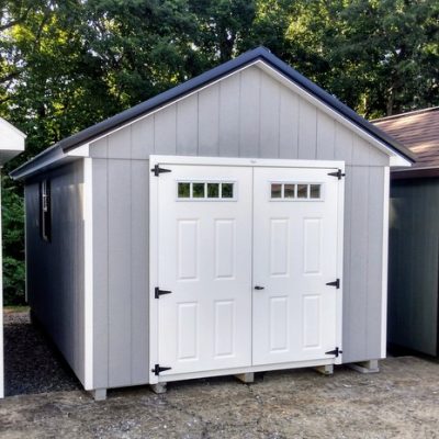 10 x 16 size painted classic style shed with gap gray siding, white trim, black metal roof, black shutters, fiber transom 6 foot double doors, two windows.