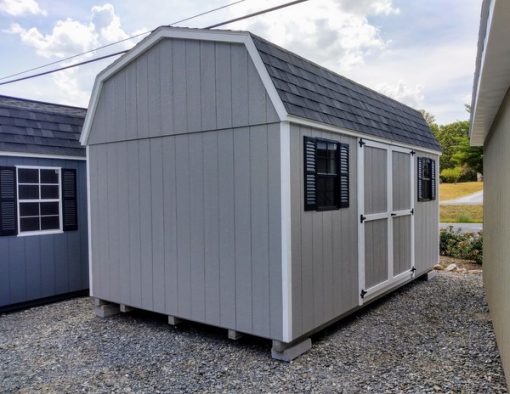 10 x 16 size painted high barn style shed with gap gray siding, white trim, black architectural shingle roof, black shutters, (1) 8' ridge vent, ggs 6 foot double doors, two black windows.