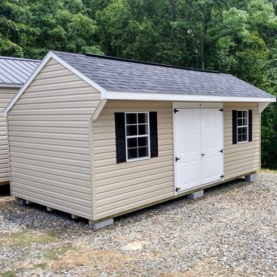 10x20 size vinyl carriage roof style shed with tan siding, white trim, black architectural shingle roof, black shutters. has (2) 8' ridge vents, 6 foot fiber doors and two windows.
