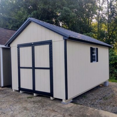 10 x 16 size painted classic style shed with navajo white siding, black trim, black metal roof, black shutters, ggs 6 foot double doors, two windows.