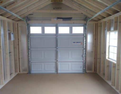 12x20 size metal classic garage style shed with white trim, polar white metal siding, black metal roof, corners and j channel, 8x7 garage door with glass, 3 foot fiber solid shed door with two windows.