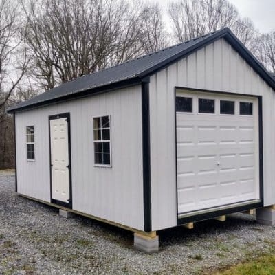 12x20 size metal classic garage style shed with white trim, polar white metal siding, black metal roof, corners and j channel, 8x7 garage door with glass, 3 foot fiber solid shed door with two windows.