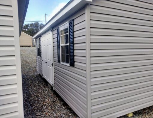 12x20 size vinyl classic roof style shed with flint siding, white trim, black architectural shingle roof, black shutters. has (2) 8' ridge vents, 6 foot fiber double doors and two windows.