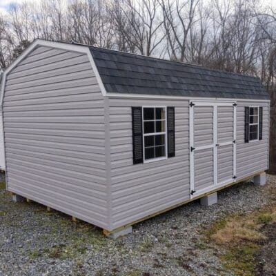 12x20 size vinyl high barn roof style shed with flint siding, white trim, black architectural shingle roof, black shutters. has (2) 8' ridge vents, ggs 6 foot double doors and two windows.