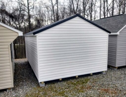 12x20 size vinyl a-roof style shed with white siding, white trim, black metal roof, black shutters. Has 6 foot fiber double doors and two windows.