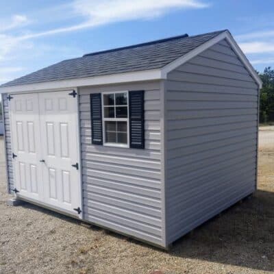 10x12 size vinyl a-roof style shed with flint siding, white trim, black architectural shingle roof, black shutters. has (1) 8' ridge vent, 6 foot fiber doors and two windows.