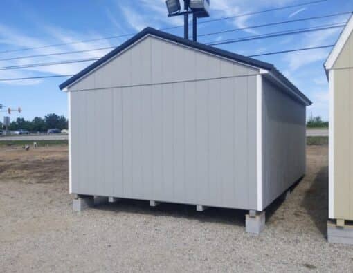 12 x 20 size painted a-roof style shed with gap gray siding, white trim, black metal roof, black shutters, ggs 6 foot doors, two windows.